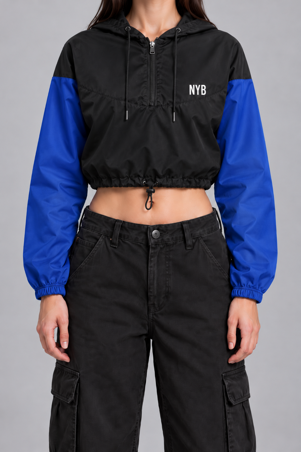 cropped half-zip windbreaker, black with cobalt blue sleeves and a small white NYB on the chest, on model, front view from the collarbone down