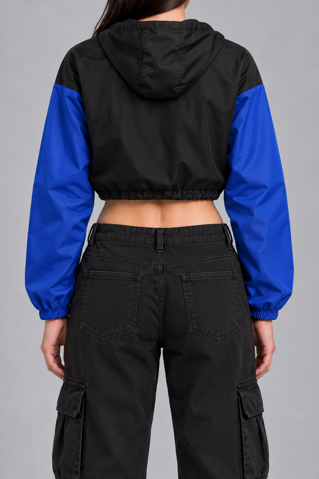 cropped half-zip windbreaker, black with cobalt blue sleeves and a small white NYB on the chest, on model, back view