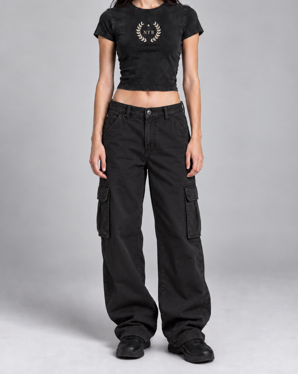 snow-washed black crop tee with a small cream laurel crest reading NYB on the chest, on model, front view from the collarbone down