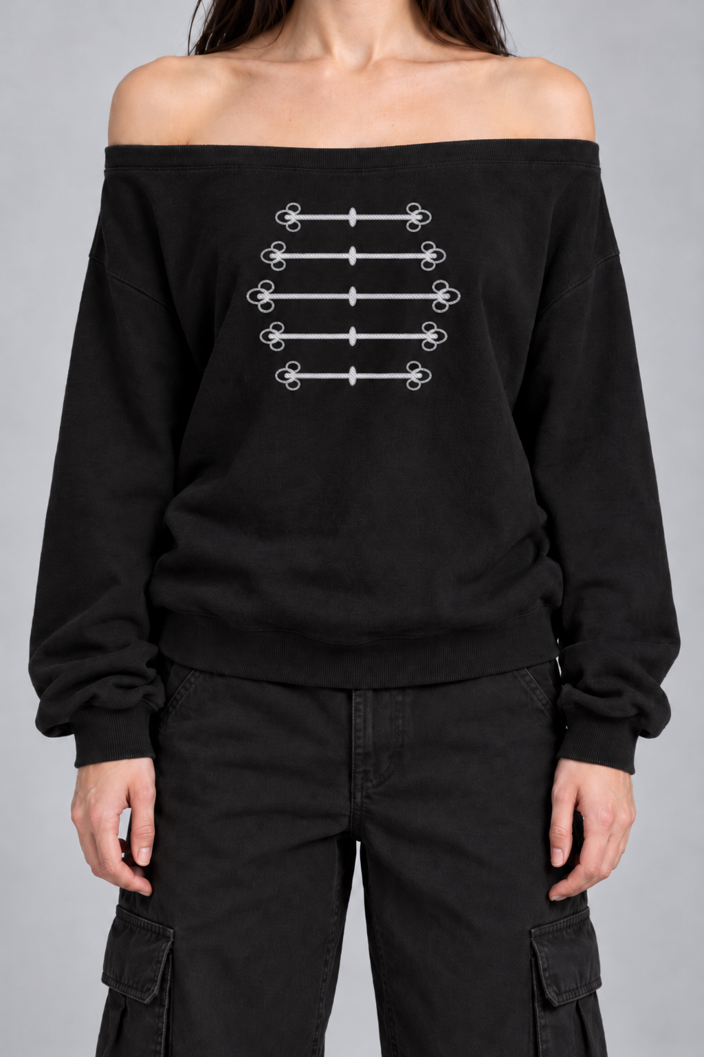 black off-shoulder sweatshirt with silver-grey military frogging across the chest, on model, front view from the collarbone down